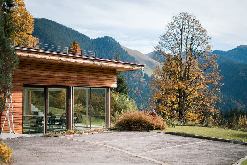 Seminarhaus Berghaus Spitzingsee mit herbstlicher Berglandschaft – Tagungsort bei Rosenheim
